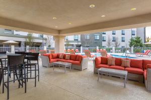 un patio con sofás y mesas rojos y una piscina en Hampton Inn & Suites San Diego-Poway, en Poway
