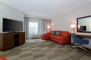 波威的住宿－聖地亞哥波威希爾頓恆庭旅館&套房酒店，客厅配有红色沙发和平面电视