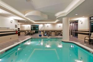 a pool in a hotel with tables and chairs at Hampton Inn & Suites Bellevue Downtown/Seattle in Bellevue