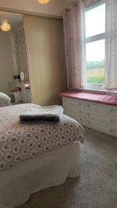 a bedroom with a bed with a dresser and a window at Idyllic Countryside Retreat in Durham County near Sedgefield in Trimdon Grange