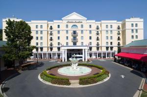 Hampton Inn & Suites South Park at Phillips Place في تشارلوت: مبنى ابيض كبير وامامه نافورة