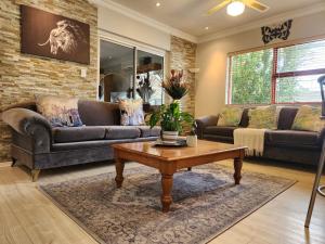 a living room with couches and a coffee table at Shalom On The Bay in Cape Town