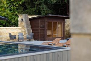 a group of chairs sitting on a patio next to a pool at Barton Hall Hotel & Spa in Kettering