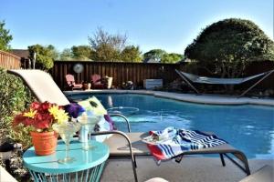 - une table et des chaises à côté de la piscine dans l'établissement Gorgeous Plano Home ~ Private Backyard Pool Oasis, à Plano