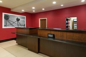 una sala d'attesa con pareti rosse e cassa di Hampton Inn & Suites National Harbor/Alexandria Area a National Harbor