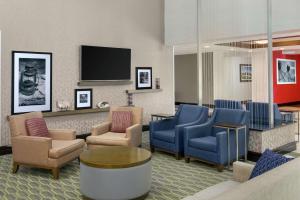 uma sala de espera com cadeiras e uma televisão de ecrã plano em Hampton Inn & Suites National Harbor/Alexandria Area em National Harbor