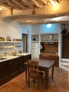 a kitchen with a wooden table and a dining room at Casa Tradicional Alpujarreña in Capileira