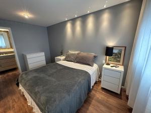 um quarto com uma cama e duas mesas de cabeceira brancas em Apartamento no Estreito em Florianópolis