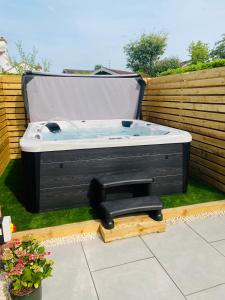 a hot tub sitting on the grass in a backyard at The Red Lodge Annexe in Woodborough