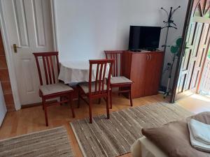 ErdőhorvátiにあるKazsimér Vendégházのリビングルーム(テーブル、椅子、テレビ付)