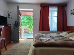 um quarto com uma cama grande e uma porta de vidro deslizante em Kazsimér Vendégház em Erdőhorváti