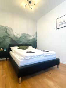 un letto in una stanza con un dipinto sul muro di Lahn küsst Rhein - Ferienwohnung a Lahnstein