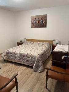 1 dormitorio con 1 cama y una foto en la pared en Appartamento in villetta sulle dolomiti di Brenta, en Pracorno di Rabbi