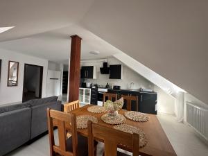 a living room with a dining room table and a kitchen at Apartament Oksford 2 in Okszów