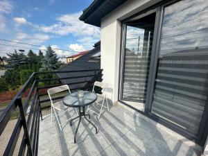 a patio with a table and chairs on a balcony at Apartament Oksford 2 in Okszów