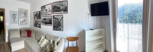 sala de estar con sofá y TV en la pared en Appartamento in villetta sulle dolomiti di Brenta, en Pracorno di Rabbi