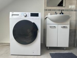 a washing machine in a bathroom next to a sink at Apartament Oksford 2 in Okszów