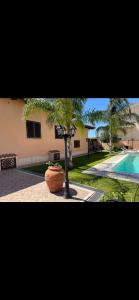 una casa con un árbol frente a una piscina en Villa Letizia, en Anzio