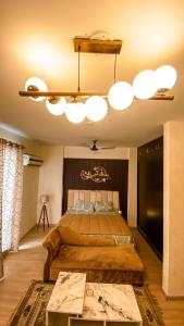 a bedroom with a large bed and a chandelier at Caramel DLF My Pad in Lucknow