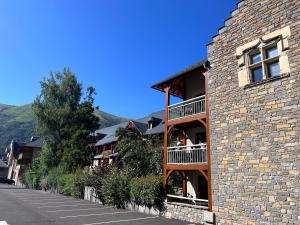 a building with a balcony on the side of it at Le Rioumajou 2 in Saint-Lary-Soulan