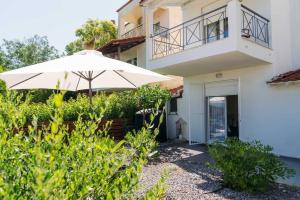 a white umbrella in front of a house at Villa olion in Afitos