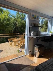 a room with a sliding glass door to a patio at Drakes Mead Retreat - Shepherd's Hut in Axminster