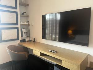 una grande TV a schermo piatto appesa a un muro di 8010 Urban Living- Luxury Home Experience a Bogotá