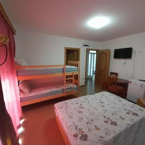 a bedroom with two bunk beds and a television at Vila Bolonja in Struga