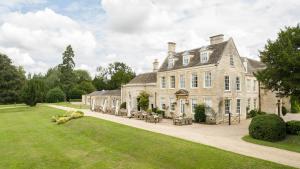 a large stone house with a lawn in front of it at Barton Hall Hotel & Spa in Kettering