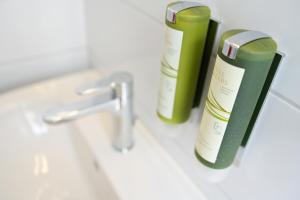 two bottles ofodorizers sitting on a bathroom sink at Hotel & Restaurant Nollen in Hosenruck