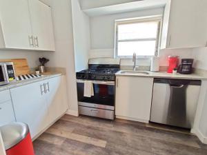 a kitchen with white cabinets and a stove and a sink at Cozy 1BDR In Central Philly Hosted By StayRafa 2R in Philadelphia