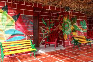 two benches sitting in front of a wall with graffiti at Hostal La Guaca in Cartagena de Indias