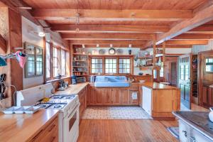 uma grande cozinha com pisos e tectos em madeira em Tranquil Washington Home with Sauna, on 70 Acres em Washington