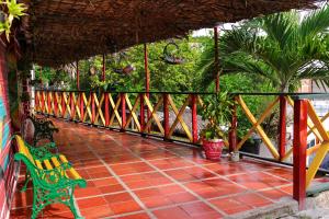 a porch with a bench and some plants and trees at Hostal La Guaca in Cartagena de Indias