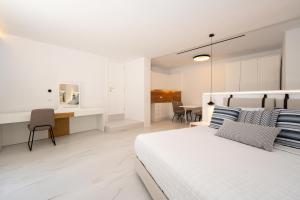 米克諾斯城的住宿－Arcs Boutique Villa Hotel，白色卧室配有床和书桌