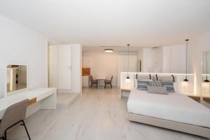 a white bedroom with a bed and a table at Arcs Boutique Villa Hotel in Mikonos