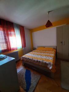 a small bedroom with a bed and a rug at Apartman Sofka in Vranje