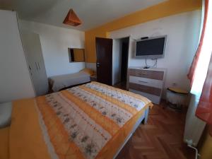 a bedroom with a bed and a flat screen tv at Apartman Sofka in Vranje