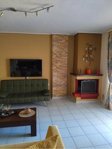 a living room with a couch and a fireplace at AM Apartment on the beach in Lefkandi Chalkidas