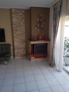 a living room with a fireplace and a television at AM Apartment on the beach in Lefkandi Chalkidas