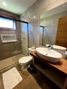 a bathroom with a sink and a toilet and a shower at Charmoso Chalet in Teresópolis