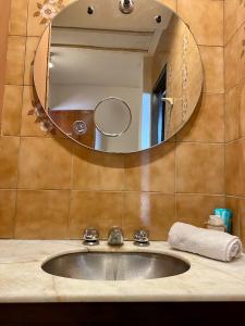 a sink in a bathroom with a mirror at Open House Hostel in Mendoza