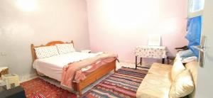 a small bedroom with a bed and a table at One bedroom apartment in Salé