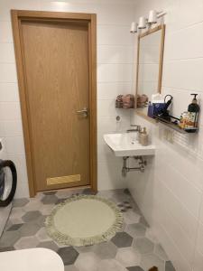 a bathroom with a door and a sink and a mirror at Apartment Upeņu in Rīga