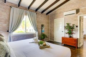 a bedroom with a large bed and a window at Shaka Caye All inclusive Resort in Belize City