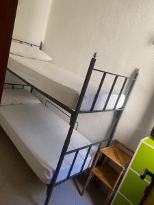two bunk beds in a small room with a stool at House pinus village in Forte Village