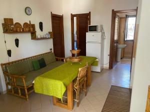a kitchen with a table with a green table cloth on it at House pinus village in Forte Village