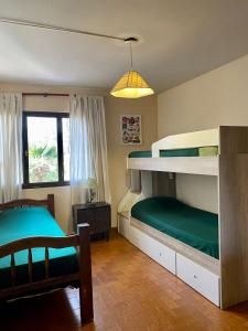 a bedroom with two bunk beds and a chair at Open House Hostel in Mendoza