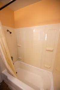 a bathroom with a white bath tub with a shower curtain at Bells Melody Motel in Mackinaw City