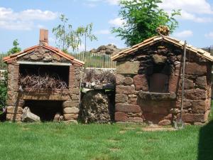 un antiguo edificio de piedra en un campo de hierba en Casa Rural La Muralla, en Retortillo de Soria